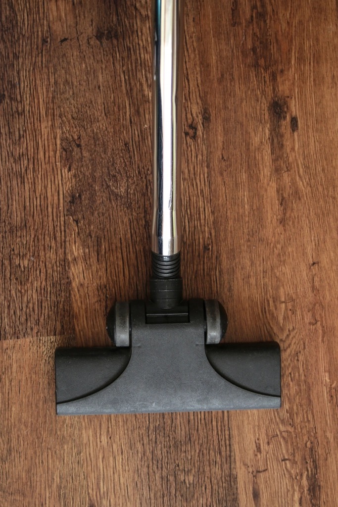 Vacuuming a hardwood floor as part of routine floor care